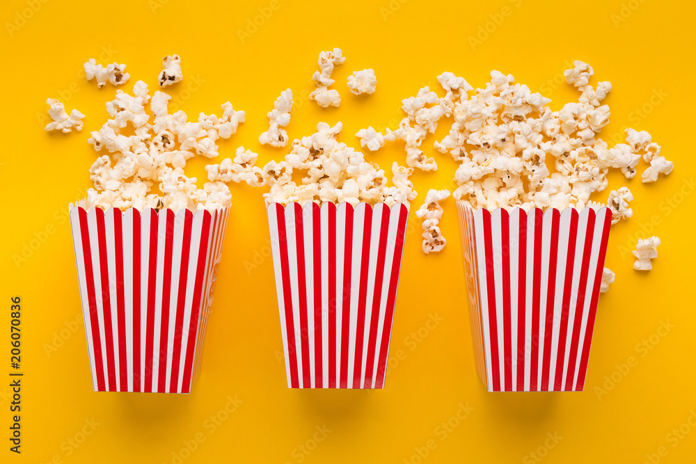 Buckets of popcorn on yellow background, top view