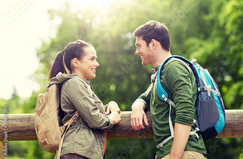 travel, hiking, backpacking, tourism and people concept - smiling couple with backpacks in nature looking and talking to each other © Syda Productions