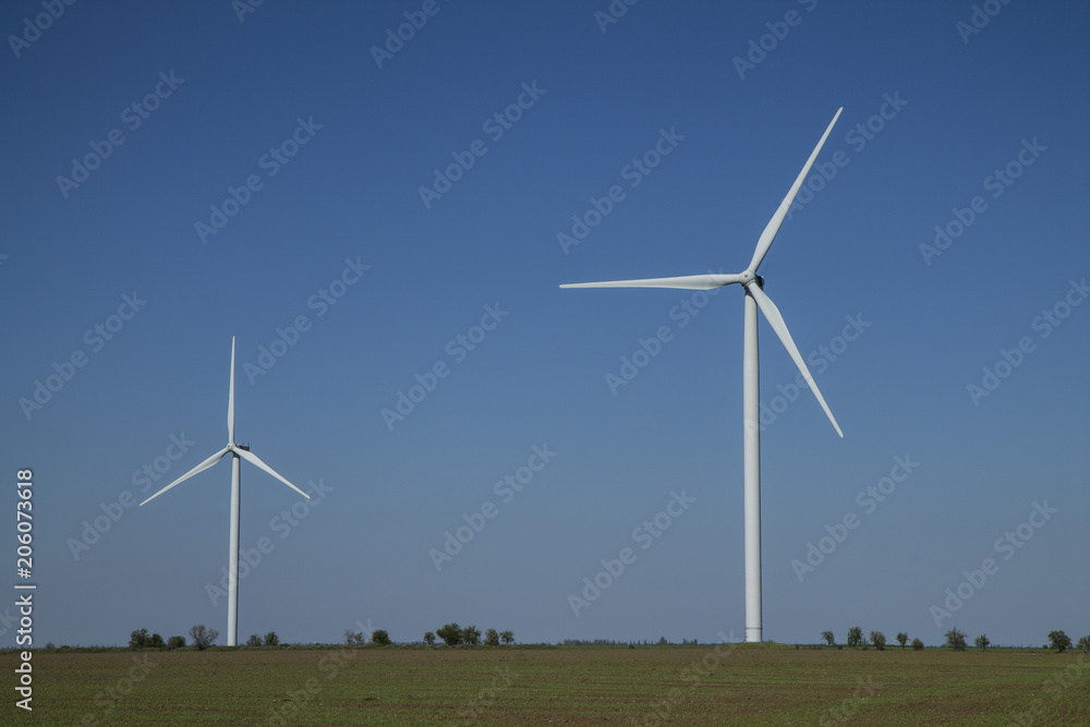 Wind energy turbines on sunset sky background, Energy generator nature friendly. Spring field. Wind energy turbines on sunset sky background, Energy generator nature friendly. Spring field.