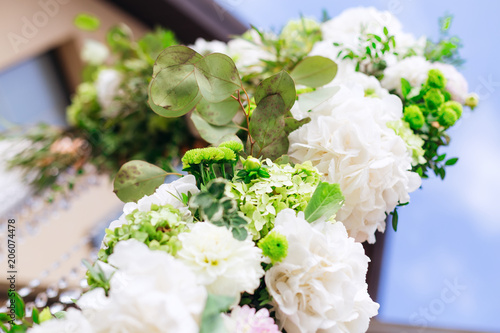 Close-up of white flowers in a flower arrangement on the background of the sky and the building © Ivan