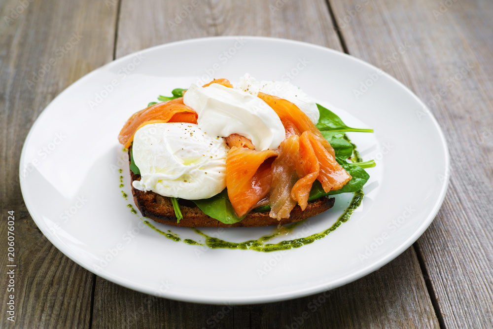 Healthy breakfast, restaurant menu photo, delicious meals with proteins and low fat. Wholemeal bread toast and poached egg with smoked salmon and green salad, Healthy breakfast, restaurant menu photo, delicious meals with proteins and low fat. Wholemeal bread toast and poached egg with smoked salmon and green salad,