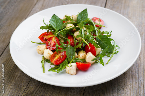 Healthy vegetarian Caprese salad with tomatoes, basil and mozzarella cheese. Italian appetizer, gourmet food, banquet, restaurant menu concept.