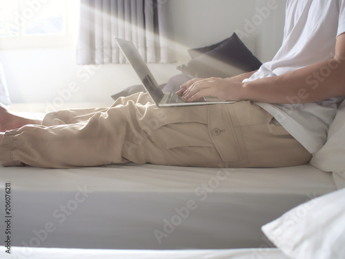 Cropped image of young man using computer laptop in living room