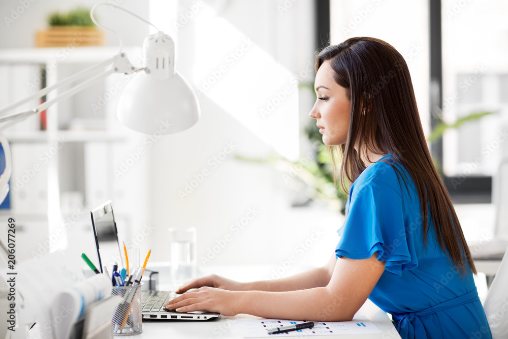 business, technology and people concept - businesswoman with laptop computer working at office