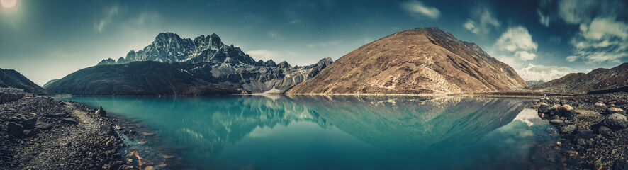 Spectacular scenery the crystal clear Gokyo Lake on the mighty snow-covered Himalayas background. Strength and beauty of wild virgin nature. Ideal image for the backgrounds and wallpapers.