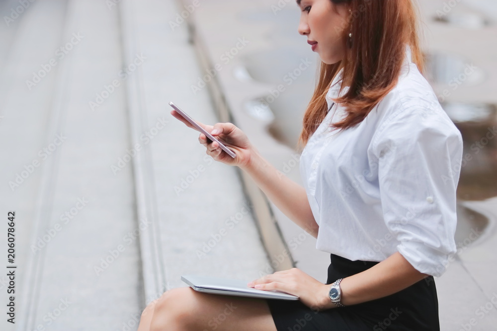 Obraz premium Beauty young Asian business woman using laptop and mobile smart phone for job at outside office.