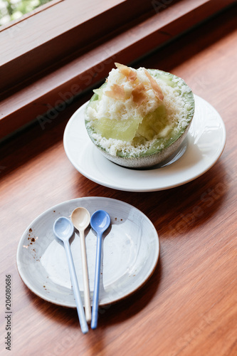 Japanses melon Kakigōri (shaved ice dessert) served in half of melon and sliced Pama Ham. With Dessert spoons in plate. photo