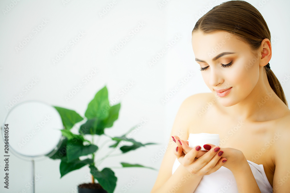 Beautiful model applying cosmetic cream treatmen on her face Beautiful model applying cosmetic cream treatmen on her face