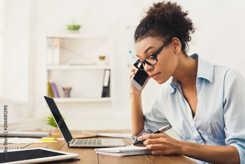 Serious woman consulting by phone at office Serious woman consulting by phone at office