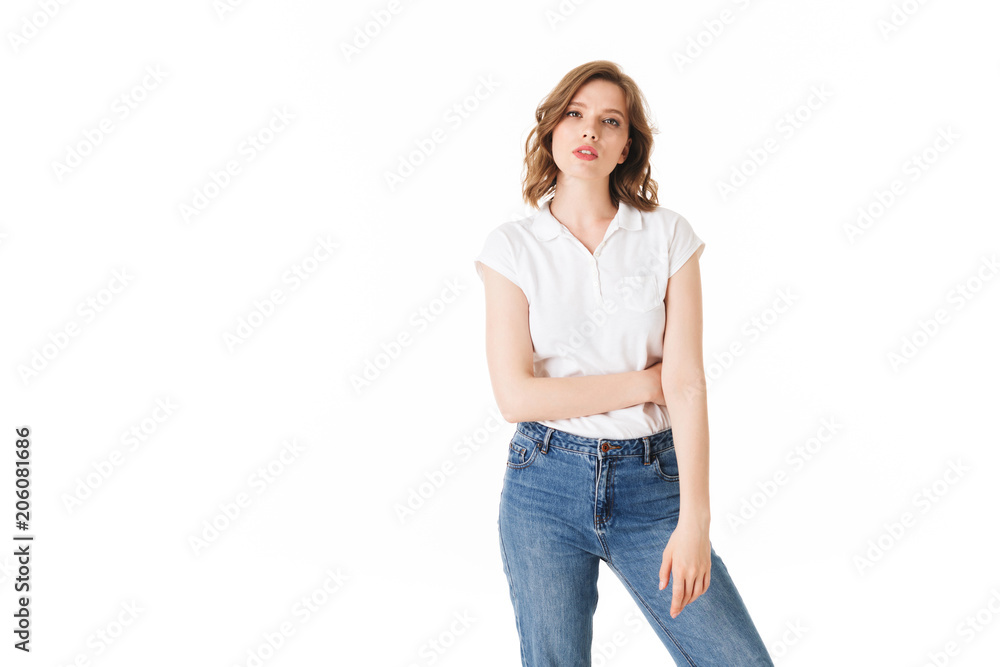 Portrait of young pensive lady standing in t shirt and jeans and thoughtfully looking in camera on white background isolated Portrait of young pensive lady standing in t shirt and jeans and thoughtfully looking in camera on white background isolated