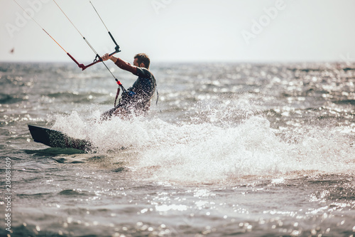 Kitesurfing Kiteboarding action photos man among waves quickly goes