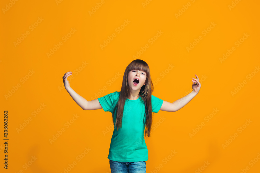 Beautiful female half-length portrait on orange studio backgroud. The young emotional teen girl Beautiful female half-length portrait on orange studio backgroud. The young emotional teen girl