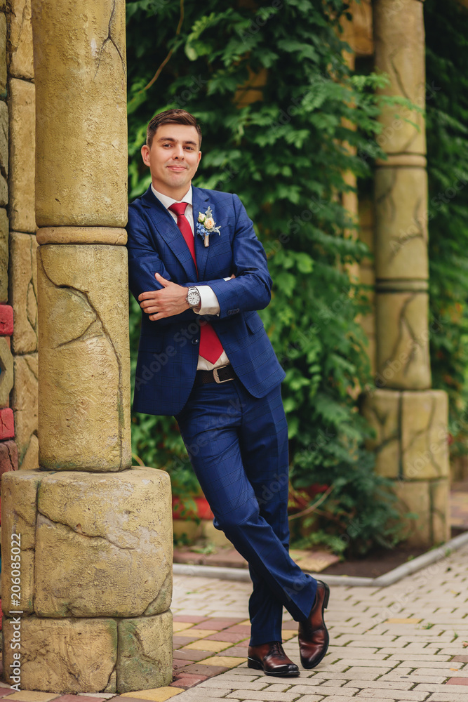 Happy stylish elegant groom in a blue suit Happy stylish elegant groom in a blue suit