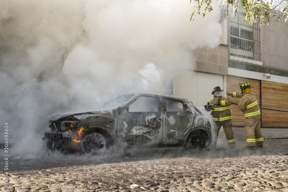 Fototapeta premium Firefighters extinguish a burning car