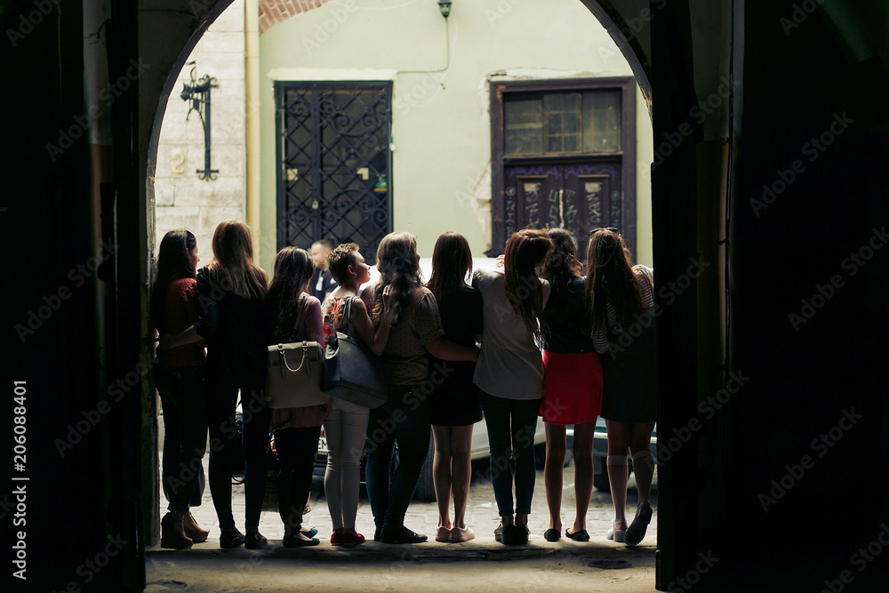 Fototapeta premium young happy women looking at old european city street, stylish hipster girls, moments of happiness, friendship concept, view from back.