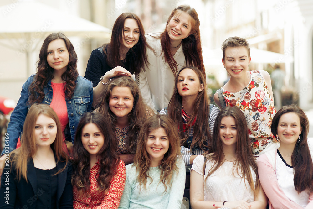 Obraz premium stylowe kobiety hipster uśmiechając się i siedząc na ławce na ulicy miasta europy, koncepcja przyjaźni radosne chwile