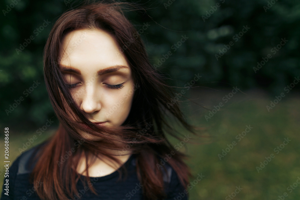 stylish beautiful woman calm portrait with windy hair posing on background green trees in summer park, space for text stylish beautiful woman calm portrait with windy hair posing on background green trees in summer park, space for text