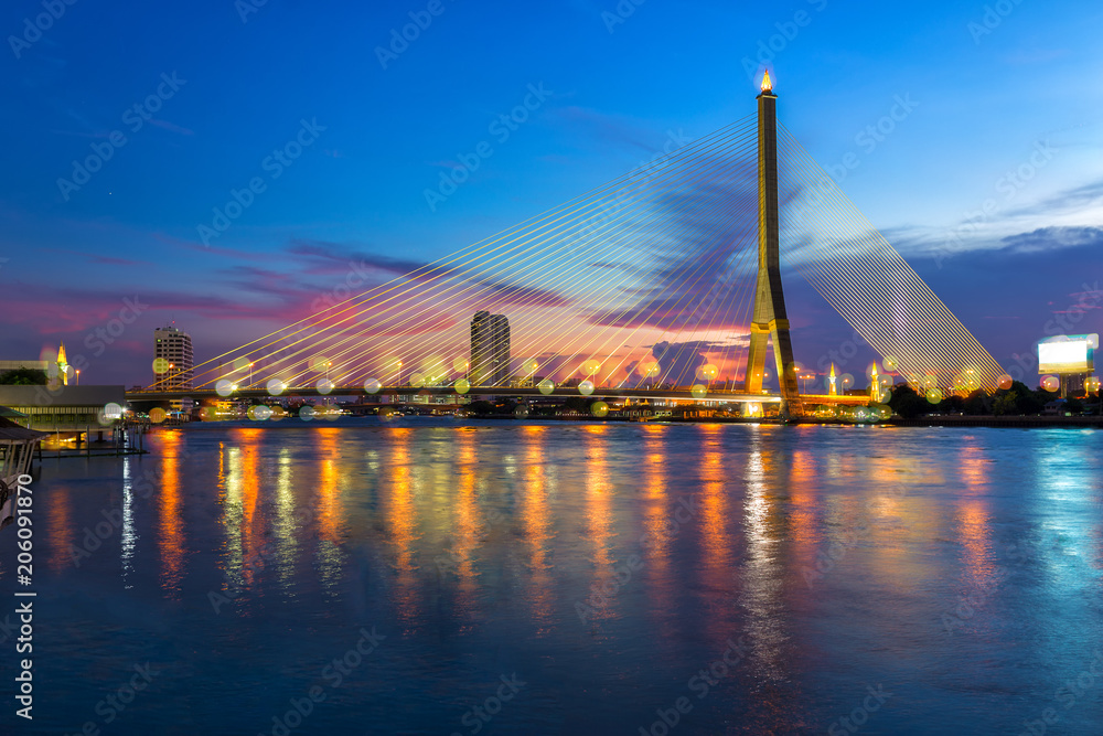 Rama 8 bridge is a cable stayed bridge crossing the Chao Phraya River and transportation at sunset, the famous landmark in Bangkok, Thailand.