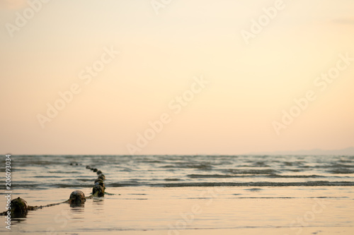 Sunset sea and beach with floating rope in evening. © AePatt Journey