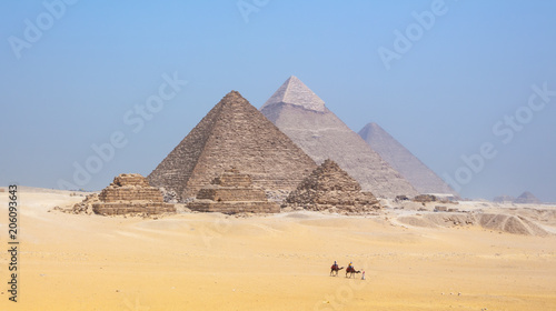 Tourists riding camels by the pyramids at Giza in Egypt