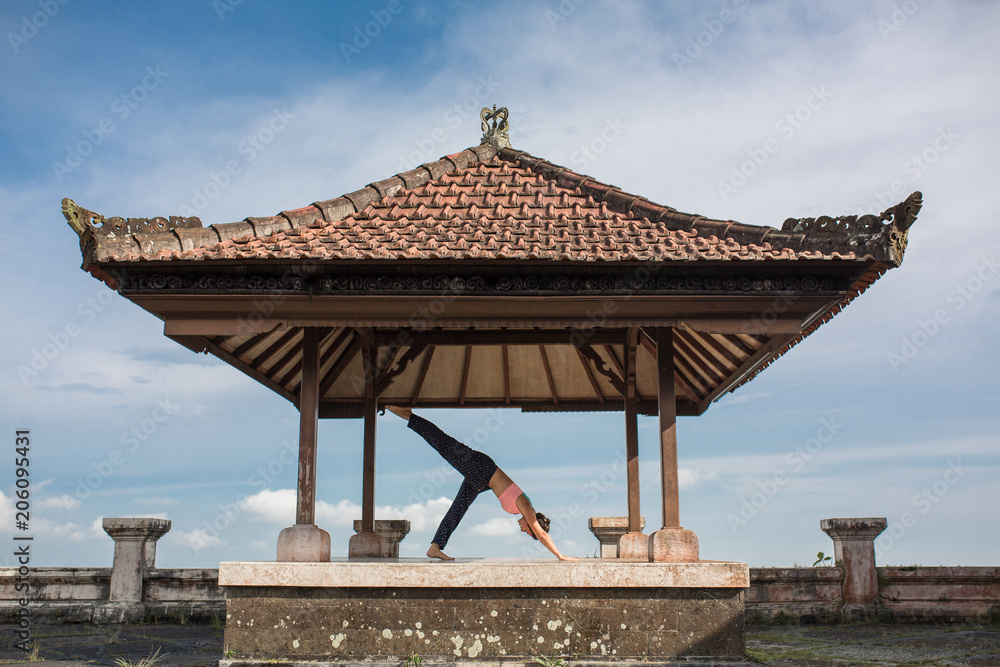 woman practicing yoga in the traditional balinesse gazebo woman practicing yoga in the traditional balinesse gazebo