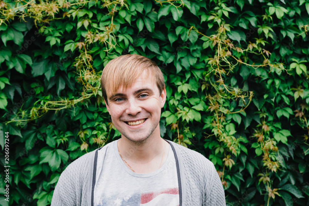 Portrait of a stylish man against a green foliage background. Portrait of a stylish man against a green foliage background.