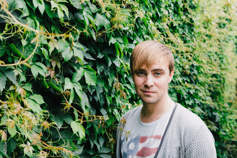 Portrait of a stylish man against a green foliage background. Portrait of a stylish man against a green foliage background.