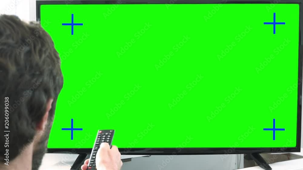 Changing Channels TV Zoom In Green Screen. Young man changing channels