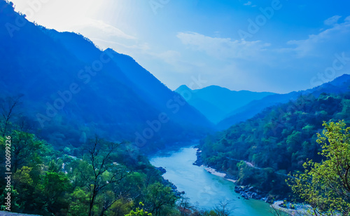 morning top view of Holy Ganges river that flows through Rishikesh passage of mountains looks divine  © Peppygraphics