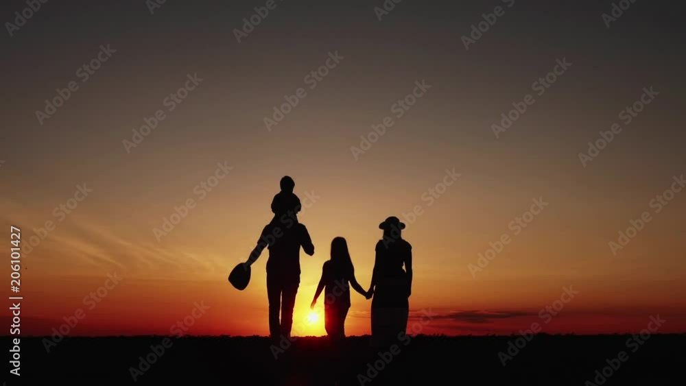 Slow Motion Silhouette at sunset happy family walking through a meadow Slow Motion Silhouette at sunset happy family walking through a meadow