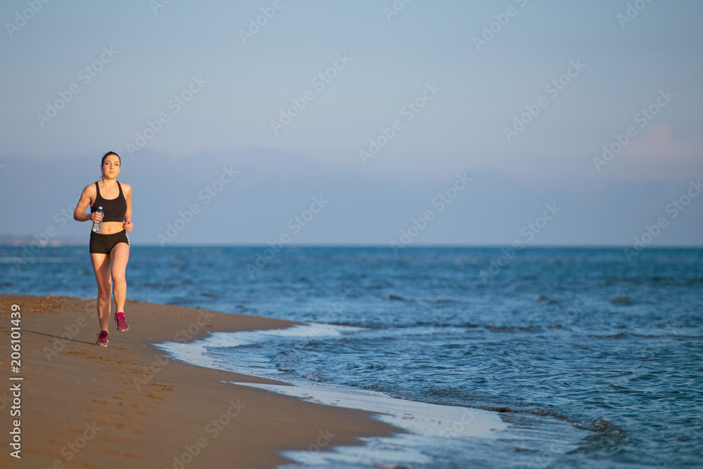 Healthy young fitness woman runner running on sunrise seaside trail Healthy young fitness woman runner running on sunrise seaside trail