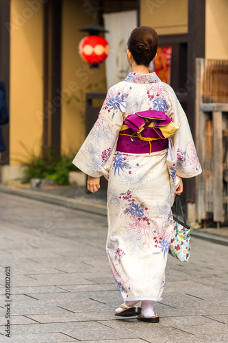 Girl in a kimono on a city street, Kyoto, Japan. Vertical. Copy space for text.