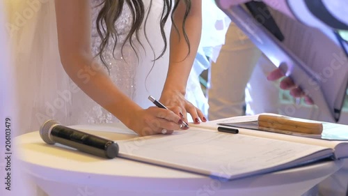 White bride signing marriage paper