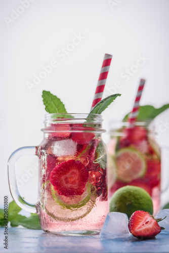 Close up view on lime and strawberry detox drink in glass mason jars on a blue background Selective focus. 13 photo