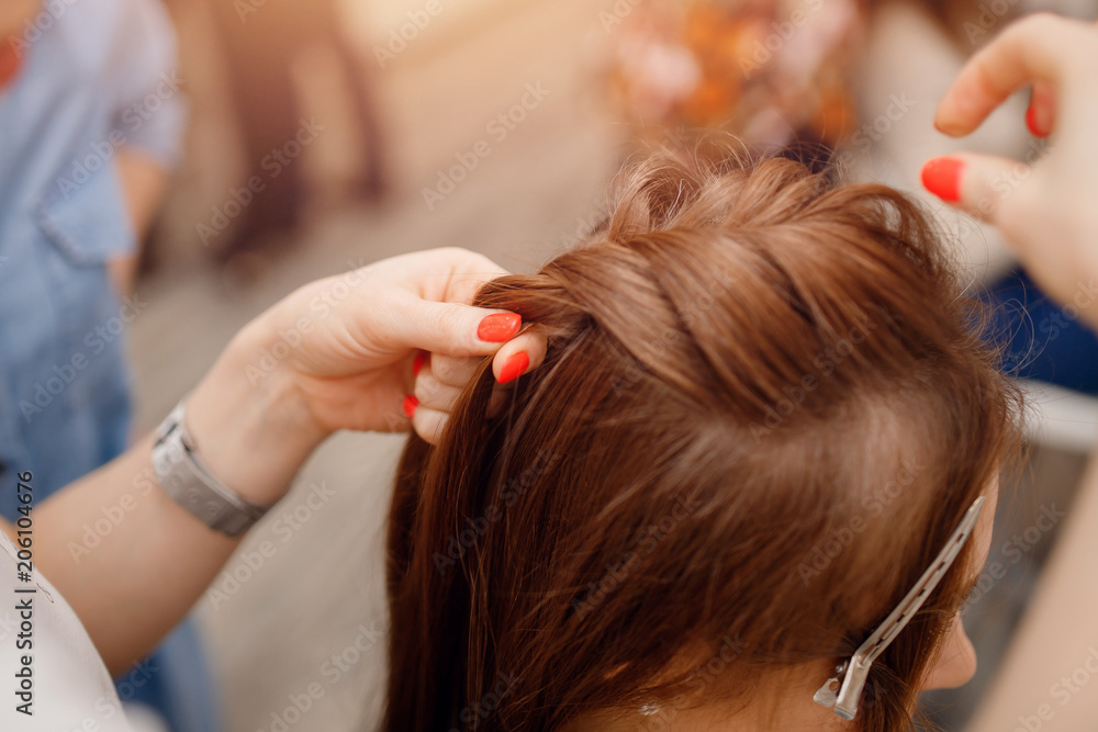 Woman hairdresser making hairstyle to blonde girl in beauty salon. Woman hairdresser making hairstyle to blonde girl in beauty salon.