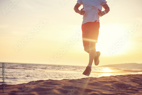 Fototapeta Naklejka Na Ścianę i Meble -  Man running on the beach at sunset