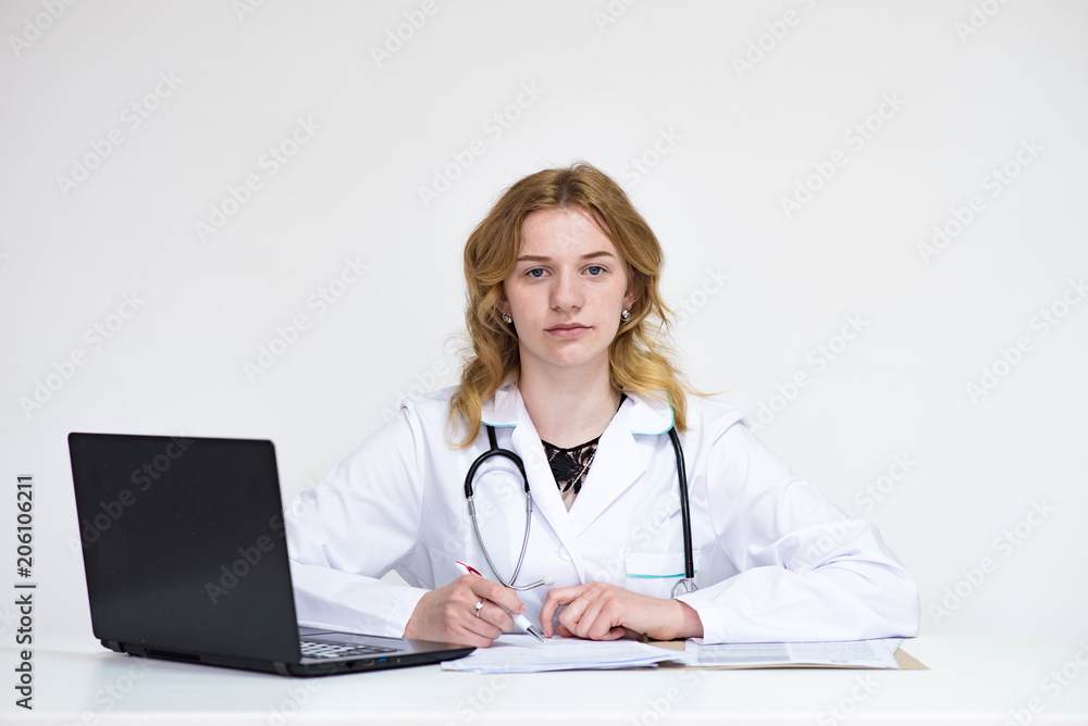 Portrait of a beautiful blonde doctor girl on white background with a laptop Portrait of a beautiful blonde doctor girl on white background with a laptop