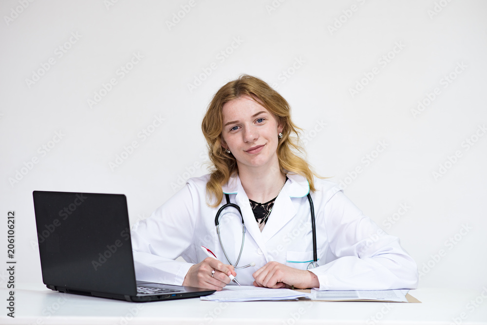 Portrait of a beautiful blonde doctor girl on white background with a laptop Portrait of a beautiful blonde doctor girl on white background with a laptop