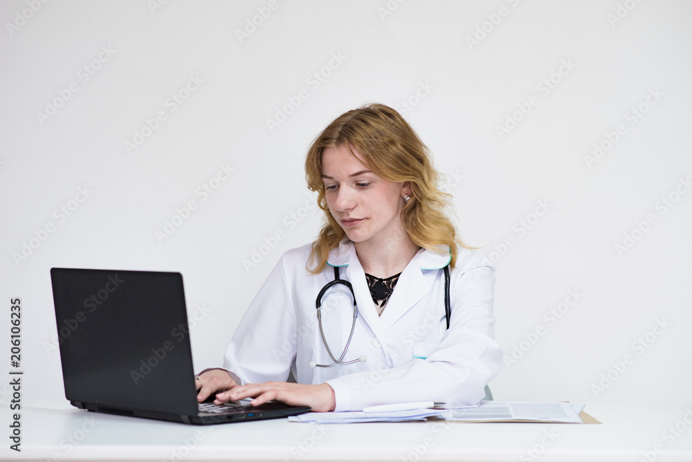 Portrait of a beautiful blonde doctor girl on white background with a laptop Portrait of a beautiful blonde doctor girl on white background with a laptop