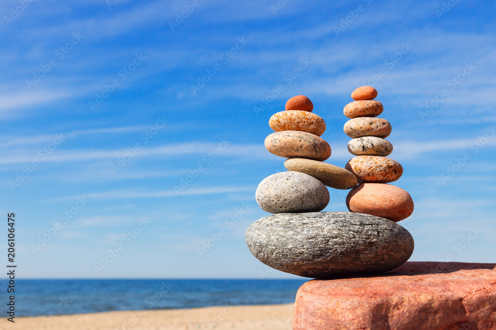 Fototapeta premium Równowaga kamieni na tle błękitnego nieba i morza