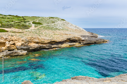Mallorca, Blue clear clean sea water of little bay Cala Estreta on eastern holiday island with cliffs