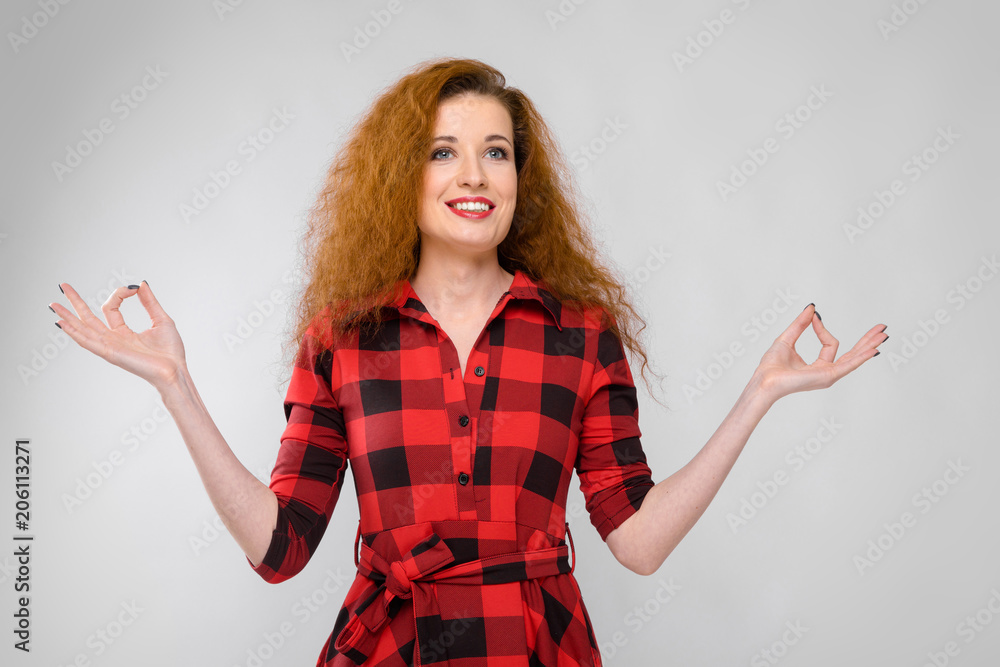 Young red-haired girl in a red checkered shirt. Young girl meditates Young red-haired girl in a red checkered shirt. Young girl meditates