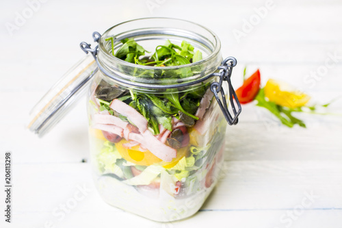 Salads with arugula  radish  tomatoes  seeds and cucumber in glass jars. Healthy food  diet and detox concept