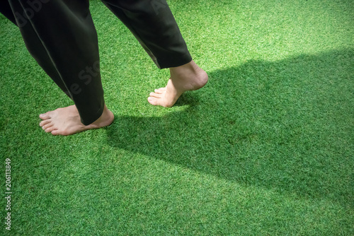 Woman legs walking on green grass