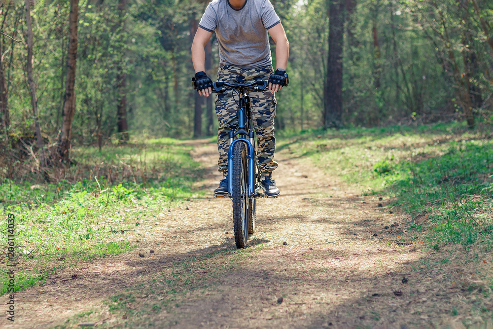 Naklejka premium A man on a bike riding on a forest trail