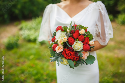 closeup gorgeous wedding bouquet of roses in hands of bride