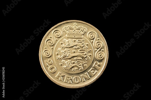 A close up image of a golden 20 kroner coin isolated on a black background