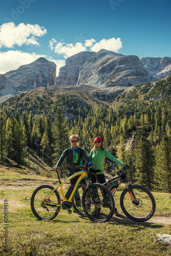 young man and woman on bikes in italien dolomites, bike tour in mountain, europe