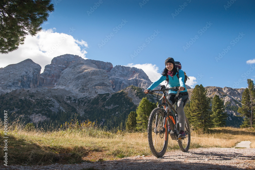 pretty young woman on bicycle in italien dolomites,  south tyrol, platzwiese - obrazy, fototapety, plakaty 