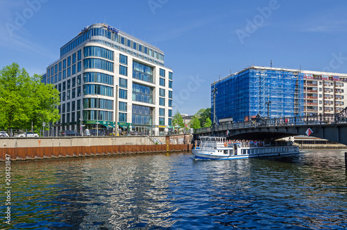  River Spree and its bank Schiffbauerdamm  tourists boats   modern building  and Riverside Hotel under reconstruction